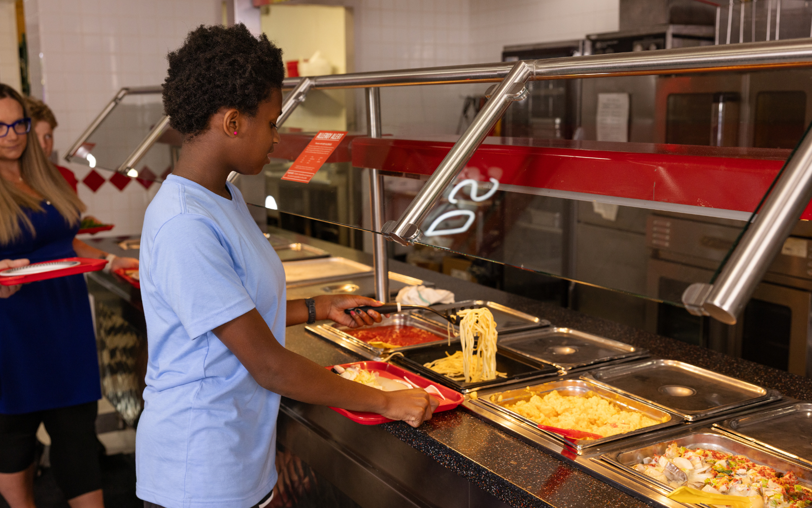 Pre-teen getting pasta at the buffet