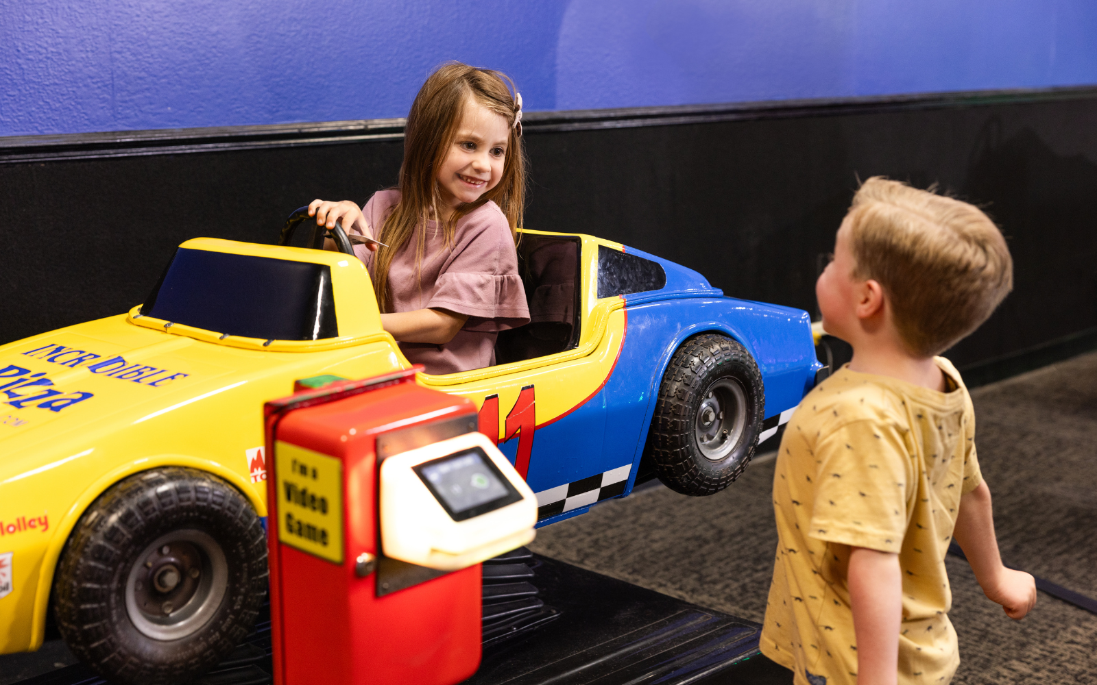 Kids smiling and riding in Tiny Town